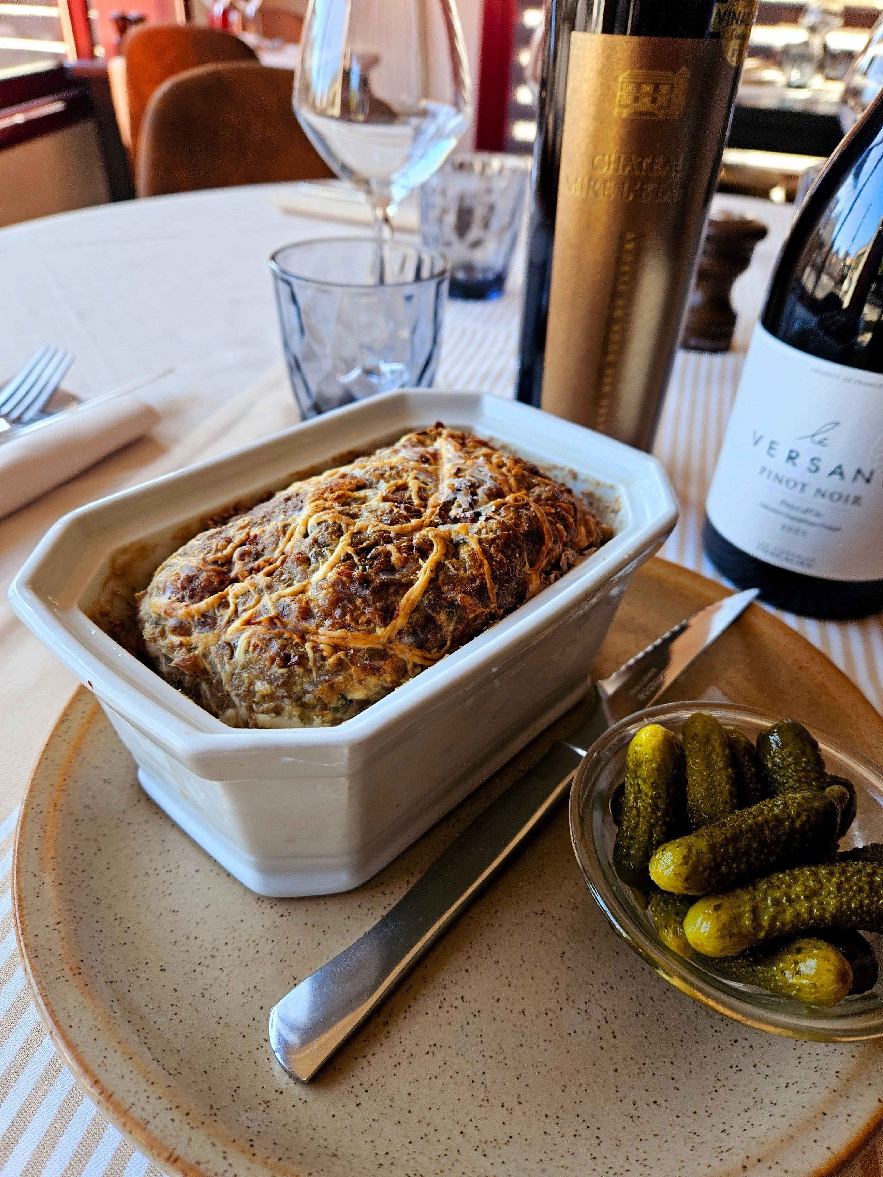 Entrée de pâté maison gratiné accompagnée de cornichons, servie sur une assiette rustique au restaurant Table 23 à Carquefou